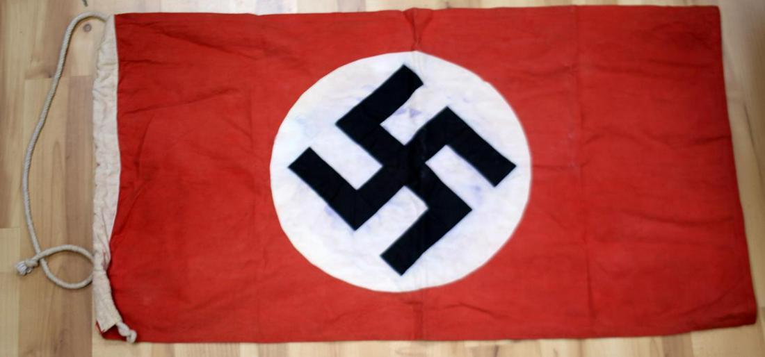 WWII GERMAN THIRD REICH FLAG WITH NATIONAL SYMBOL: Third Reich national party banner flag. Multipiece construction party symbol. Ink has bled from symbol. Measures 32 X 18 inches. Hoist is marked with measurements. Very good condition. Roundel fluores