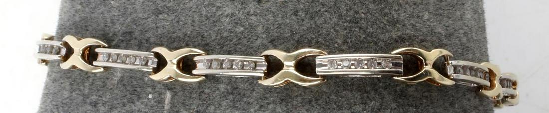 14K TWO-TONE GOLD AND DIAMOND TENNIS BRACELET: 52 single point diamonds channel set in white gold links. Each link is connected by a yellow gold X. Bracelet is 2.11 millimeters thick at white gold points and 3.94 millimeters thick at yellow gold p