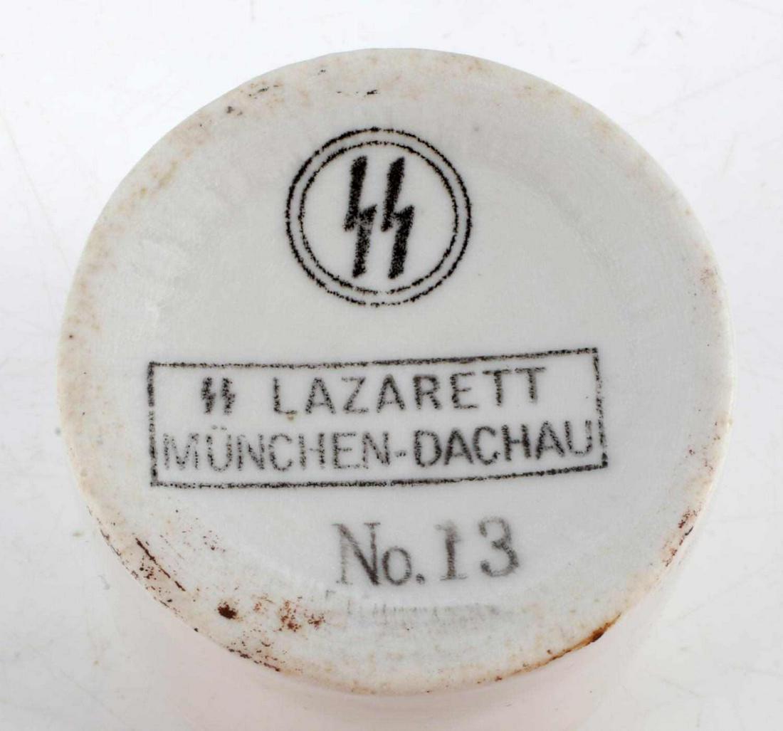 WWII GERMAN THIRD REICH DACHAU MEDICINE CUP: Measures 2 inches across and 2 inches tall, the bottom is stamped with SS Lazarett Munchen-Dachau No 13. Unauthenticated, sold as is. This lot has a reserve.