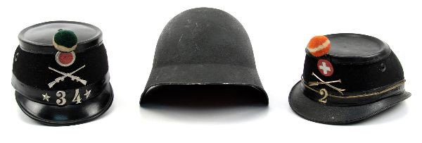 TWO SWISS MILITARY SHAKO HATS AND ONE HELMET: Two Swiss Army shako hats with pompons. Appear to be early to mid 20th century. First hat has the number "2" on the front with orange pompon, liner missing, but chin strap intact. The second with gree