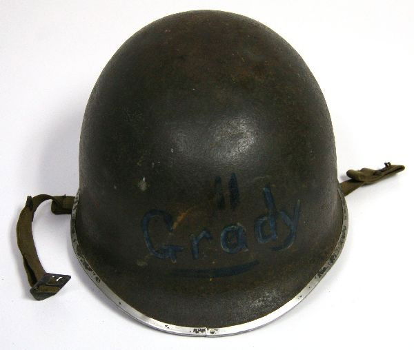 WWII M-1 FIXED BALE HELMET AND LINER: A scarce fixed bale M-1 helmet with liner, chin strap intact, early war dark drab green parkerization, some small dents to helmet and Grady is written on front.