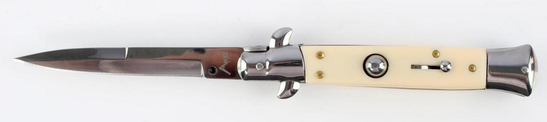 ITALIAN MADE AKC SWITCHBLADE KNIFE WHITE CELLULOID: AKC knife with stainless steel blade, white celluloid grip, and brass accents. Measures 8 3/4 inches. Very good condition.