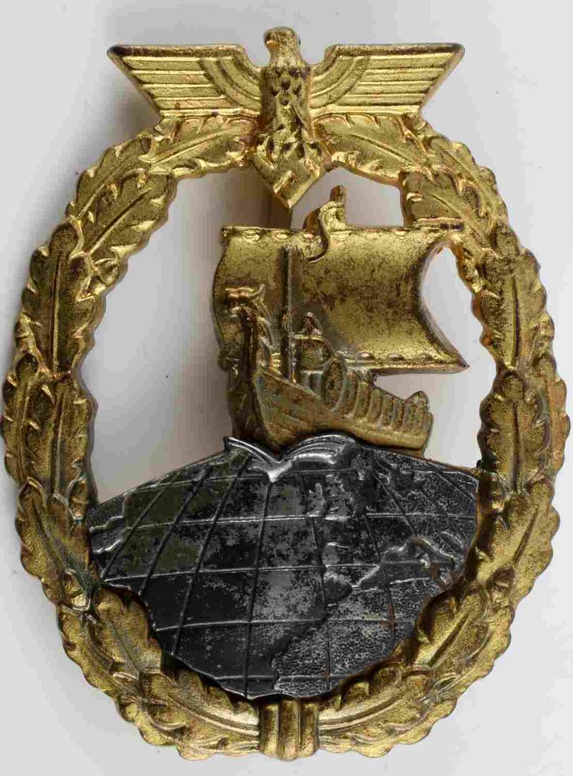 WWII GERMAN KRIEGSMARINE AUXILIARY CRUISER BADGE: Third Reich Kriegsmarine Auxiliary Cruiser badge. Schwerin Berlin marked to reverse. Wide vertical pin with C catch. Globe riveted into badge. Very good condition. Measures 2 1/4 inches.