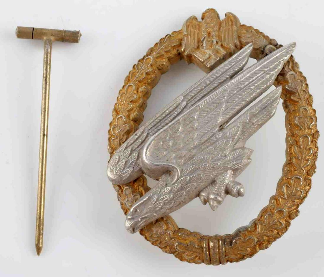 WWII GERMAN 3RD REICH LUFTWAFFE PARATROOPER BADGE: Third Reich Luftwaffe paratrooper badge by C.E. Juncker. Fallschirmjager eagle riveted on oak leaf wreath. Zinc construction. Reverse marked C.E. Juncker. Thin vertical pin with C catch. Pin has been 