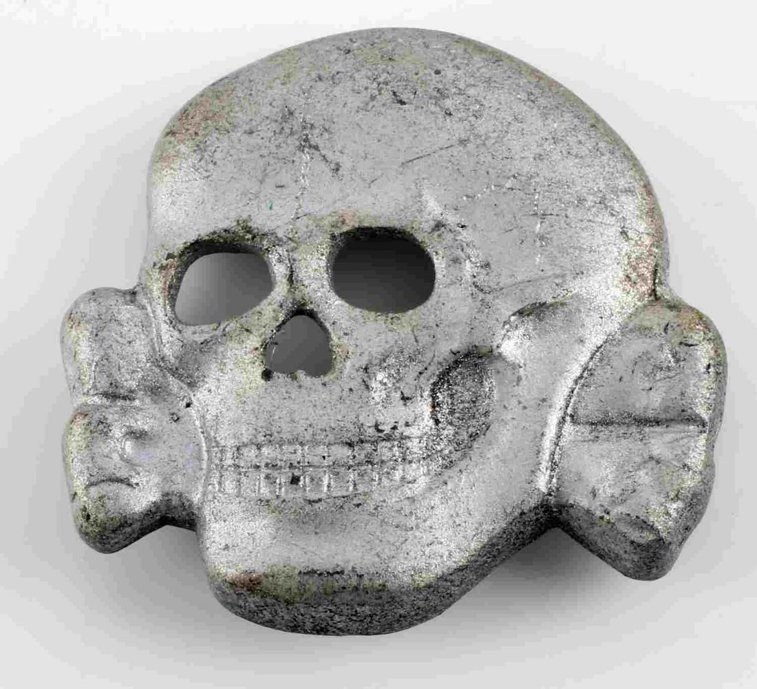 WWII GERMAN THIRD REICH WAFFEN SS VISOR CAP PIN: German WWII Waffen SS Officers Visor Cap Skull. Measures 1 1/4" wide by 1 1/8" inches tall. The front shows a Waffen SS skull and cross bones with the jaw. The reverse side is maker marked ‘RZM SS 3