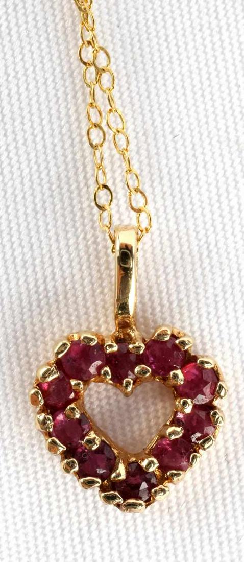 YELLOW GOLD AND RUBY HEART NECKLACE: Each of the 10 rubies is round full cut and .037 ct each, giving the necklace a tcw of .37. Bail is marked "14K" and tag on chain is marked "10K". Chain is thin cable link and 18 inches in length. Set