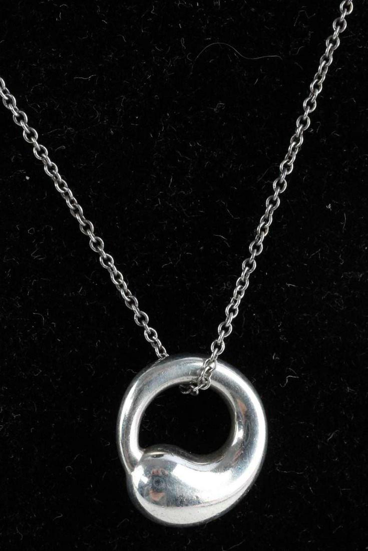 ELSA PERETTI TIFFANY & CO. STERLING BEAN NECKLACE: Elsa Peretti Bean necklace. Marked "T&Co. Peretti 925". Some light scratching present on pendant. Chain has "Tiffany & Co" sterling tag and measures 16 inches in length. This lot has a reserve. This l