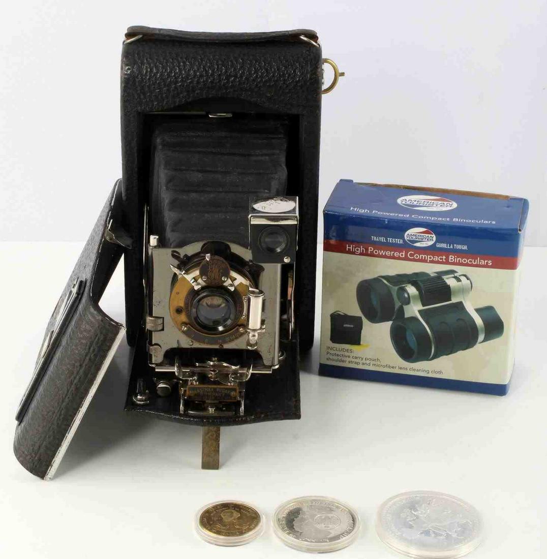 BINOCULARS KODAK CAMERA AND EUROPEAN CURRENCY: Lot features a new in box American Tourister high powered compact binoculars, a Kodak No.3 folding pocket camera, 50 Jahre German medallion, a 2003 "20" specimen coin from Malta, and a Belgium Atomium