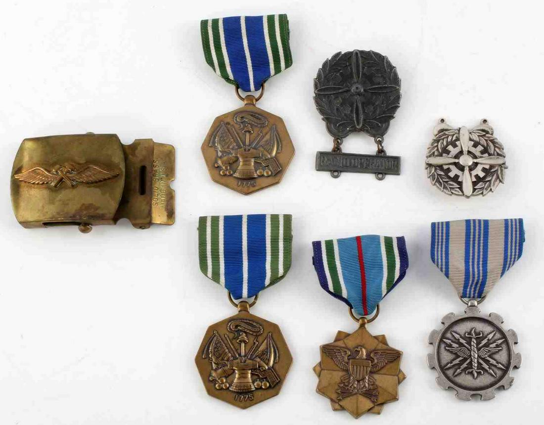 US MILITARY MEDAL LOT WITH BUCKLE AIR FORCE WWII: 7 items: two military achievement, one joint service, brass belt buckle with wings, Air Force Meritorious Achievement, WWII USAAF sterling radio operator, and pewter radio operator. Good condition.