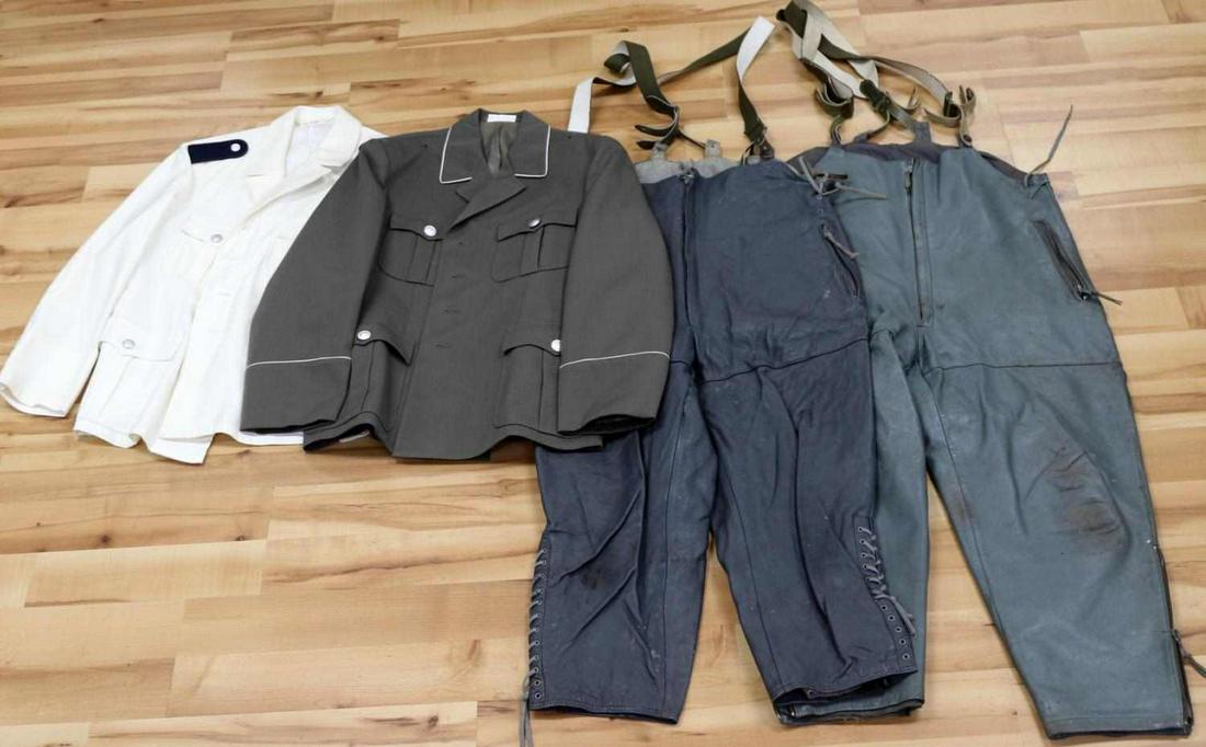 4 EAST GERMAN ARMY TRAFFIC AND NAVAL UNIFORM LOT: One white traffic police tunic with black shoulder boards. Size k52. Stamped interior NVA. One gray army officer's tunic with white piping. Size m52-1. Stamped NVA interior. Two gray U-Boat leather we
