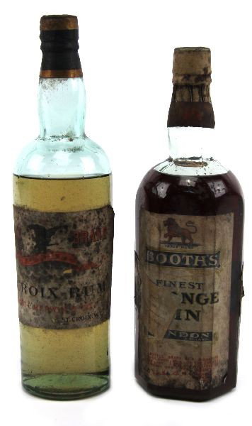 CIRCA 1920'S BOOTHS GIN ST CROIX RUM FULL BOTTLES: 2 full bottles of vintage liquor, the first Booth's gin believed to be orange gin, cork sealed with foil covering, full to just below neck, some residue at bottom, label is overall good , a dealer sti