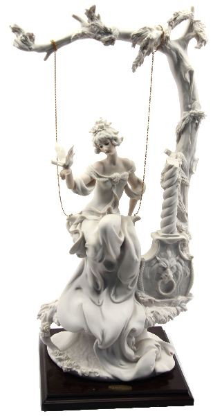 GIUSEPPE ARMANI LADY IN SWING PORCELAIN FIGURINE: A 20 inch Giuseppe Armani porcelain figurine of a young woman on a swing holding a dove. Very good condition. Includes original box and limited edition 1994 Vol. 1 Giuseppe Armani hard-back catalog.