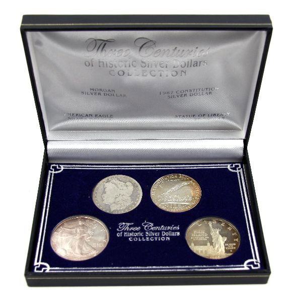 SILVER EAGLE MORGAN ELLIS & CONSTITUTION DOLLARS: A boxed set of American coins to include a 2004 silver American Eagle, 1884 Morgan dollar in G, 2 proof silver commemorative dollars- Constitution and Ellis Island.