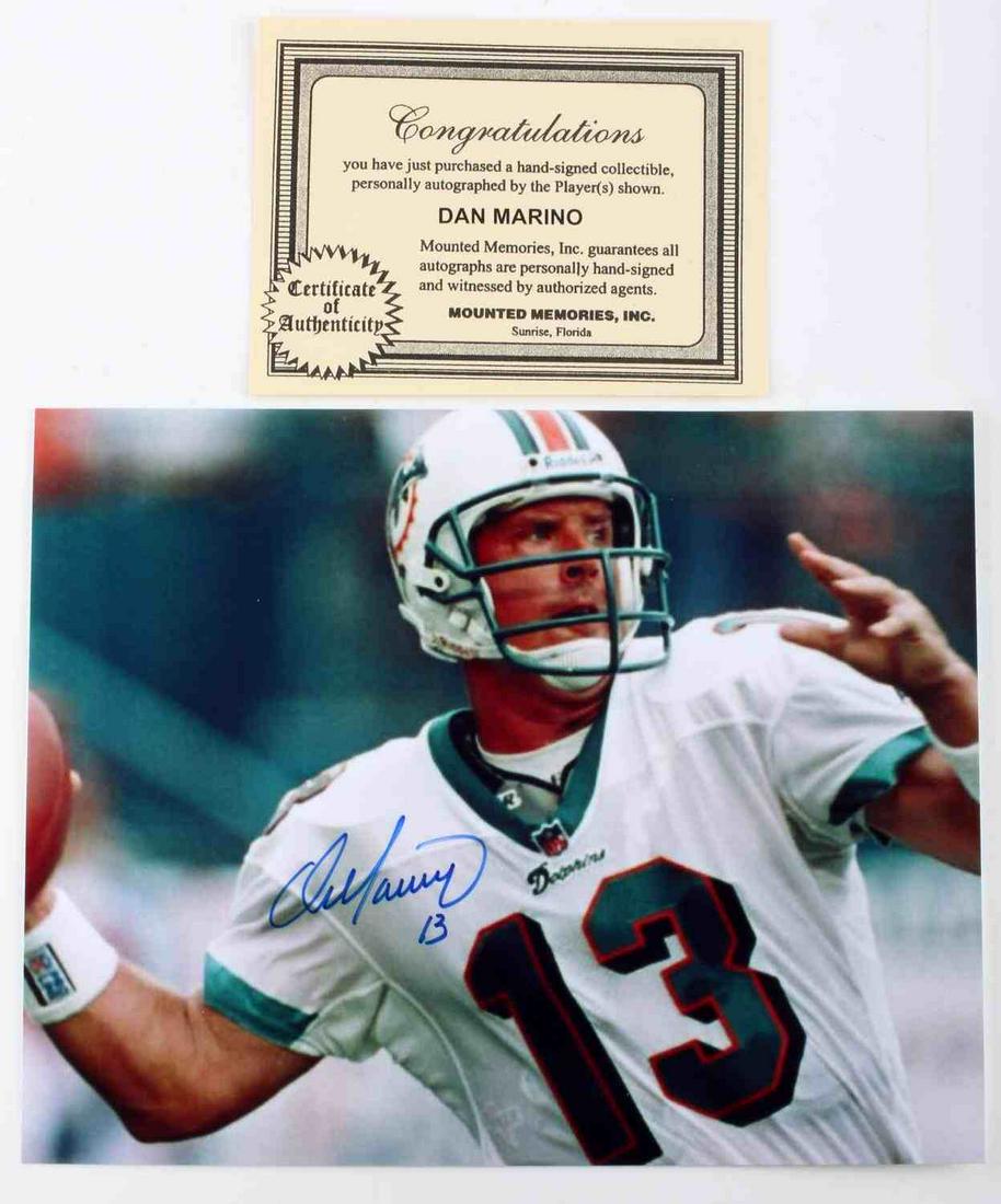 DAN MARINO SIGNED PHOTO WITH COA: Dan Marino signed photo with Certificate of Authenticity by Mounted Memories, INC. Photo features Dan Marino in #13 Miami Dolphins uniform. Signature shows his full name and "13". Both certificate and