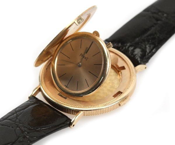 PIAGET 22K GOLD 1894 $20 GOLD COIN WATCH: Men's Piaget dress wrist watch. Full case 35mm 22k 1894 $20 Gold coin housing with 18k gold flip out watch . Black baton numerals, hour and minute hands. Signed "Piaget" and "Swiss" on face. Caiman ba