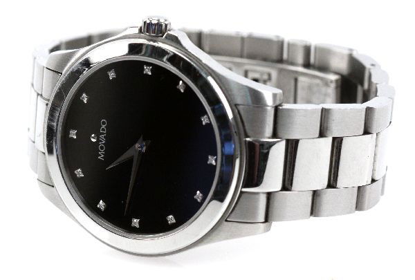 MENS MOVADO STAINLESS STEEL WRIST WATCH: Men's Movado SS wrist watch. SS band, black face with diamond set dial. 38mm in diameter. . Condition: Very good