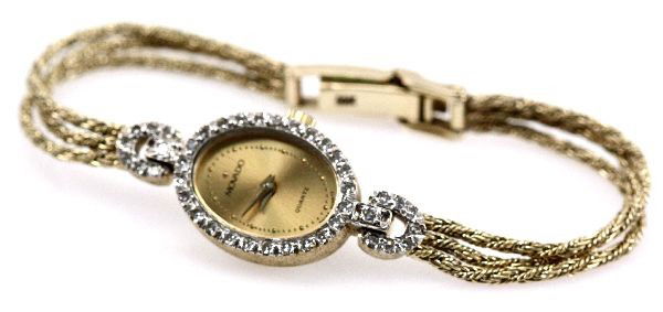 LADIES 14K GOLD & DIAMOND BEZEL MOVADO WRISTWATCH: Case#D46791637043701. (42) round cut diamond bezel totaling approx. 0.5ctw. 14K gold band and clasp. Movement: Quartz Case: 13x16mm; 14K gold Band: 6 inches; three strand 14K gold Face, Dial, Hands: G