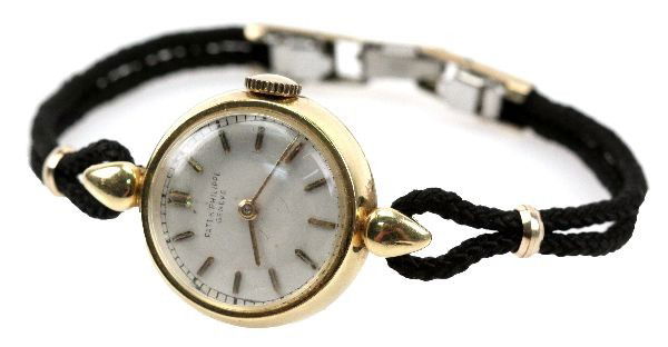 VINTAGE LADIES 18K GOLD PATEK PHILIPPE WRISTWATCH: Reverse inscribed "G.M.O.O H.V. Gray 1927-1952". Gold filled clasp. Movement: Mechanical Case: 20mm; 18K yellow gold Band: 6 inch silk band Face, Dial, Hands: White face with gold baton numerals and h