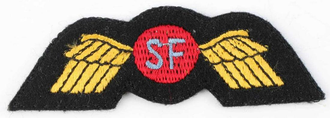 WWII US SPECIAL FORCES OSS CLOTH WING PATCH: Measures 3 3/16” wide by 1 1/16” tall. The front shows a round shield with the letters â€˜SFâ€™ in the center. It is flanked by a wing on each side. Has a black cotton mesh on the