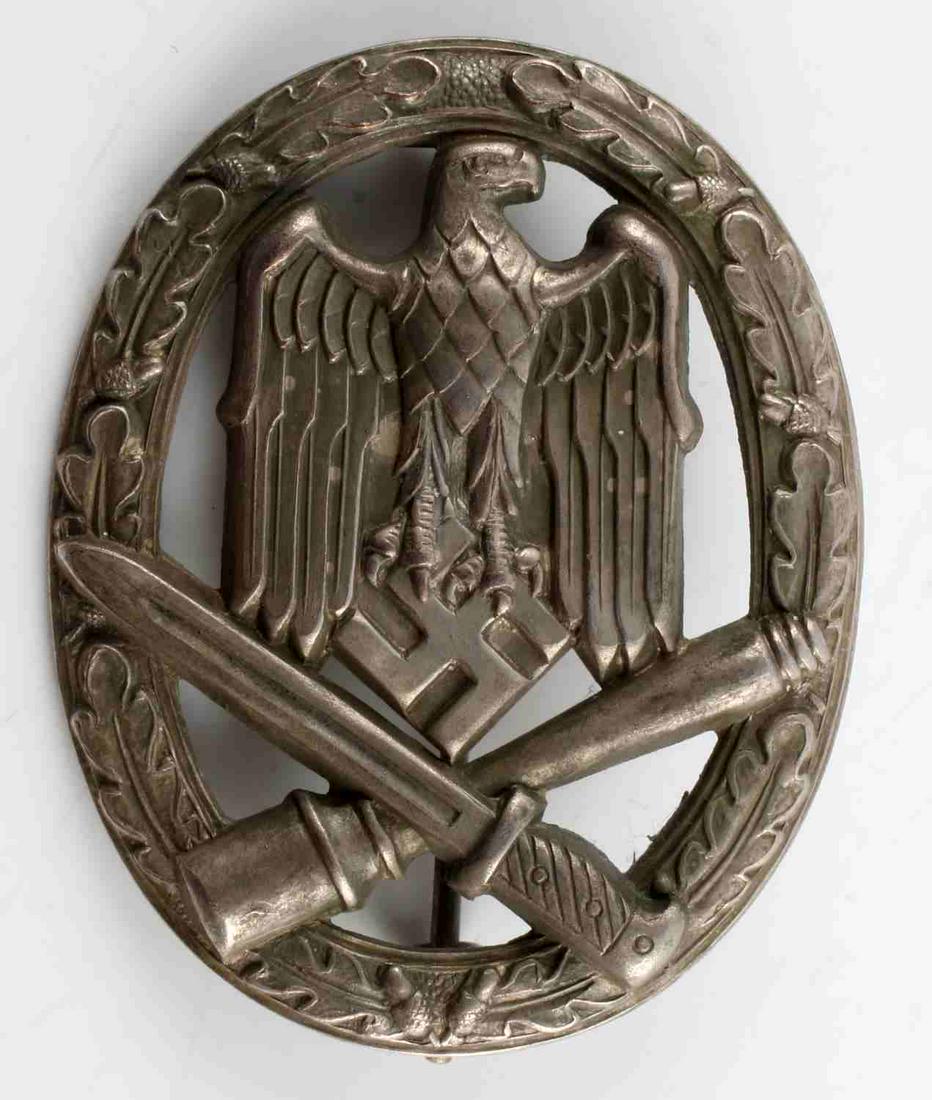 WWII GERMAN THIRD REICH GENERAL ASSAULT BADGE: WWII German Third Reich general assault badge. Measures approx. 2 X 1.75 inches.Obverse shows Totenkopf symbol over club and dagger, surrounded by oak leaf wreath. Inverse shows no markings, vertical 