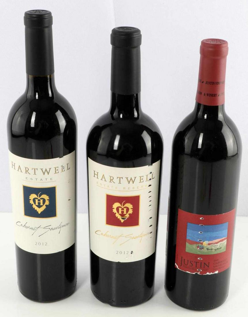 WINE BOTTLE LOT CABERNET HARTWELL 2012 JUSTIN 2009: 3 bottles: 2009 Justin (Paso Robles), 2012 Hartwell Estate Reserve (Napa), and 2012 Hartwell Estate (Napa). All bottles have intact capsule, one bottle has ullage just below capsule. Little wear to la