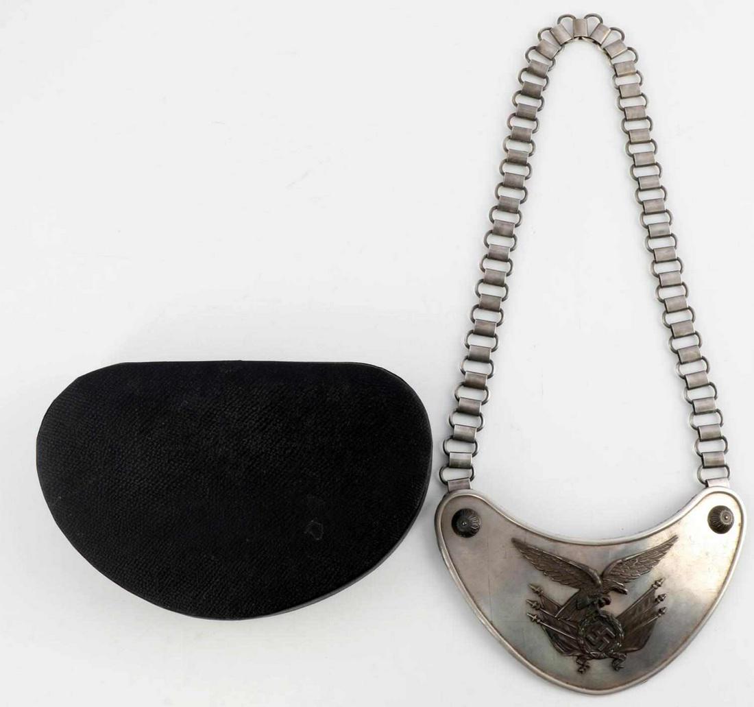 WWII GERMAN THIRD REICH LUFTWAFFE GORGET W BOX: WWII German Third Reich Luftwaffe standard gorget. Features Luftwaffe eagle clutching swastika with flags. Reverse marked C.E. Juncker Berlin. Measures 6 3/4 inches. Magnetic chain measures approximat