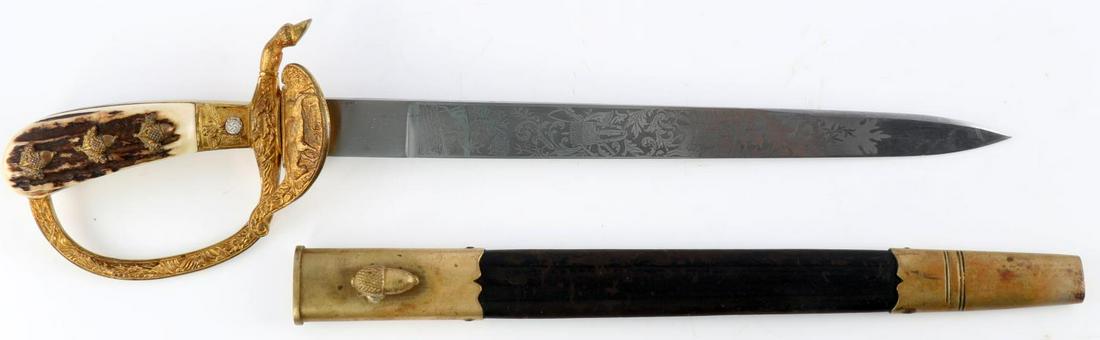 WWII GERMAN THIRD REICH HUNTSMAN DAGGER BY HOLLER: Steel blade engraved with hunting scenery with stag grip, brass gilt clamshell and D guard. Grip embellished with acorns and oak leaves. F.W. Holler marked on reverse of blade. Scabbard with leather b