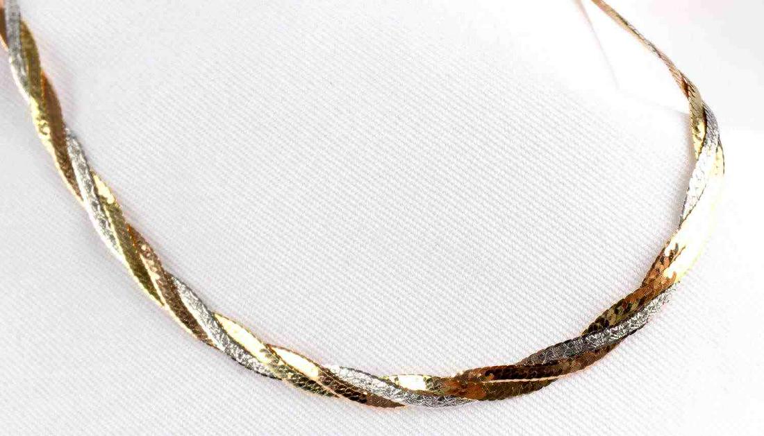 186TWISTED TRI COLOR 10K GOLD HERRINGBONE BRACELET: Marked "10K" and "ZRW", bracelet is twisted tri color gold. Each gold color is presented in a herringbone style chain and twisted together to make a multi color bracelet. White gold and yellow gold ch
