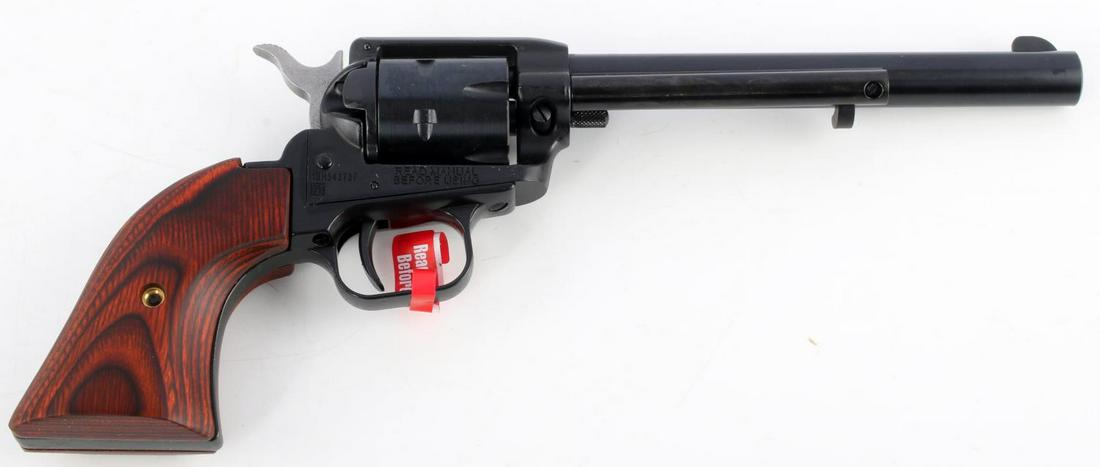 NIB HERITAGE ROUGH RIDER .22 LR 6 SHOT REVOLVER: Black blued steel, red wood grain grips, maker, model, and caliber marked to left side of 6 5/8 inch barrel, mint bore, serial number marked to right side, half moon front sight. New condition in box 