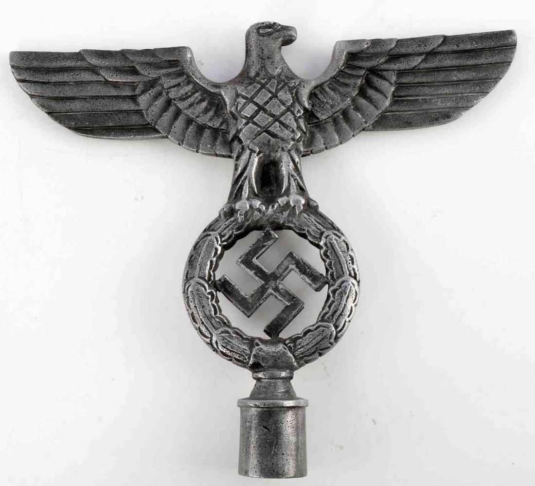 WWII GERMAN THIRD REICH REICHSADLER FLAG FINIAL: Left facing eagle clutching oak leaf wreath with swastika. Cast zinc construction. Very good condition with wear. No markings. Measures 8 inches. Unauthenticated, sold as is.