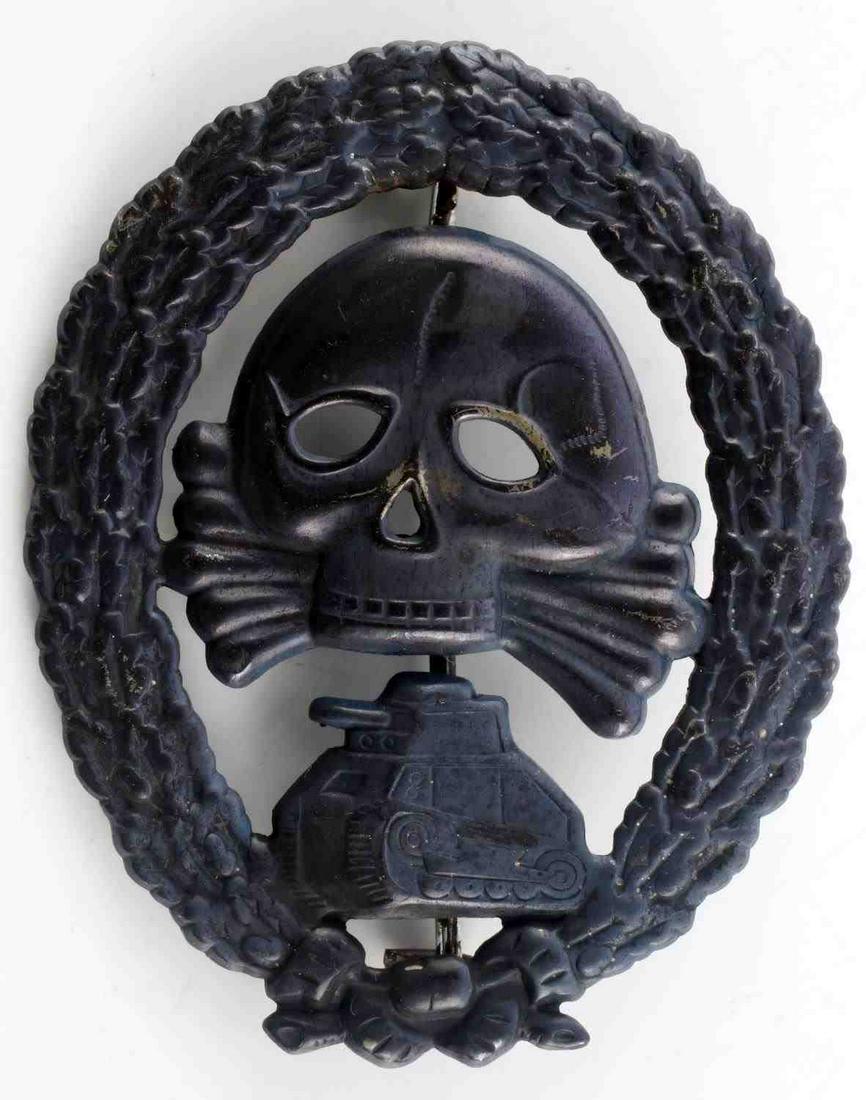 WWII SPANISH CONDOR LEGION TANK ASSAULT BADGE: Measures 1 7/8 inches wide by2 3/8 inches tall. The front shows a jawless skull and cross bones in the center with a tank below. Bothare surrounded by an oval oak leaf wreath. Has a thin vertical pin
