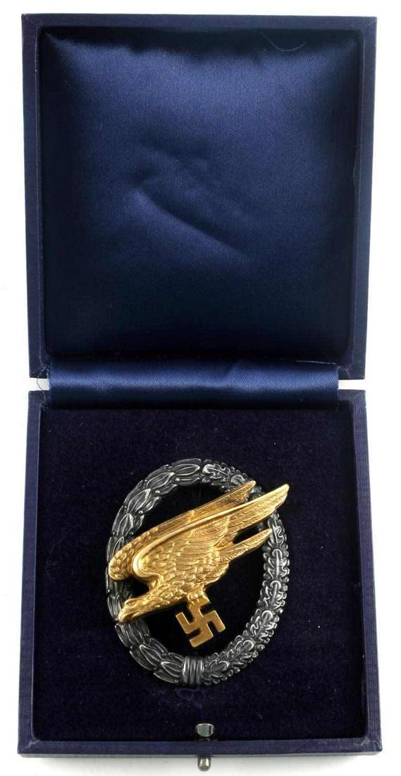 WWII GERMAN LUFTWAFFE PARATROOPER JUMP BADGE: Cased German WWII Luftwaffe Paratrooper Fallschirmjager Jump Badge. Measures 1 11/16” wide by 2 1/8” tall. The front shows a diving eagle clutching a swastika in his talons in the center. Both are