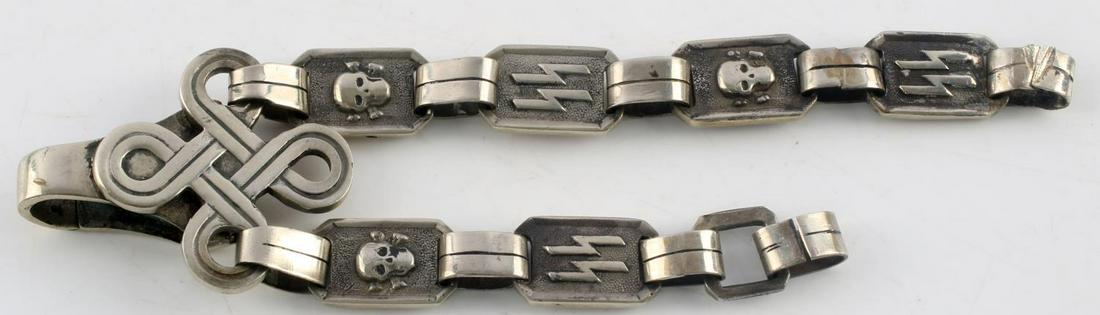 WWII GERMAN THIRD REICH SS HONOR DAGGER CHAIN: Measures 1 7/16 X 6 inches. The front shows the Waffen SS runic link and the Waffen SS skull and cross bones link. The dagger clip is in fine working order. RARE. Die struck nickel construction. Excel