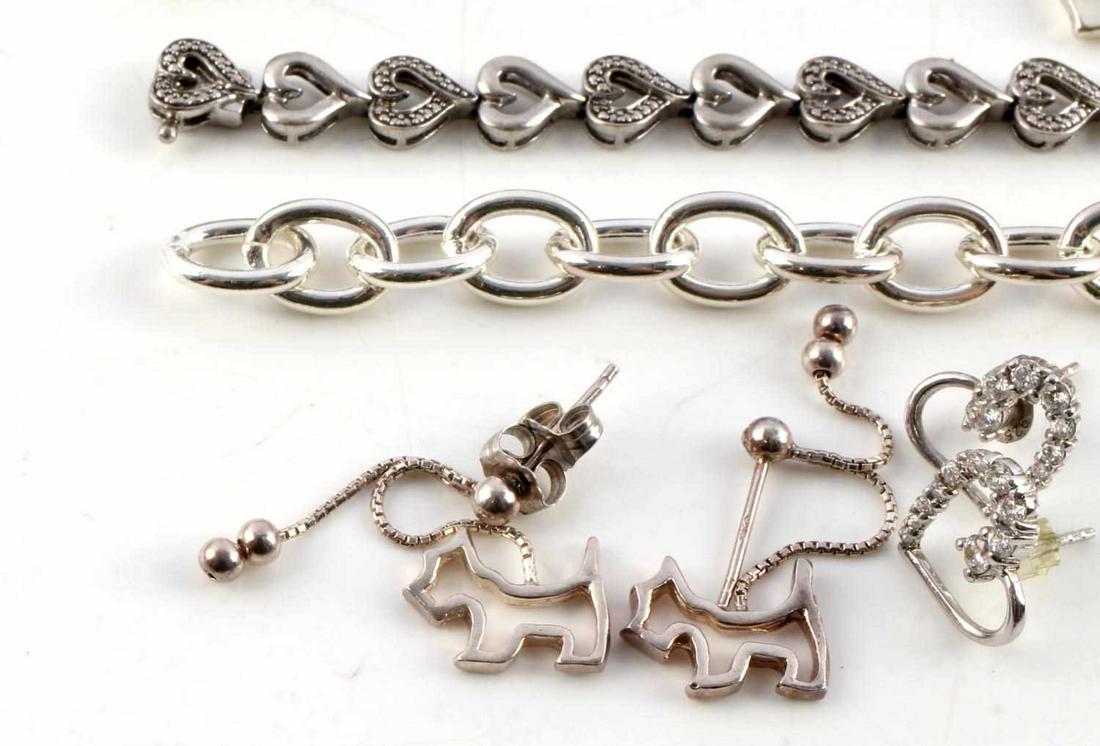 STERLING SILVER JEWELRY LOT WITH STONE DETAILS: Sterling Silver Jewelry Lot Features: Sterling heart earrings with clear stone details. Sterling drop down earring featuring Scottish terrier charms. Circular necklace charm with biblical engraving. S