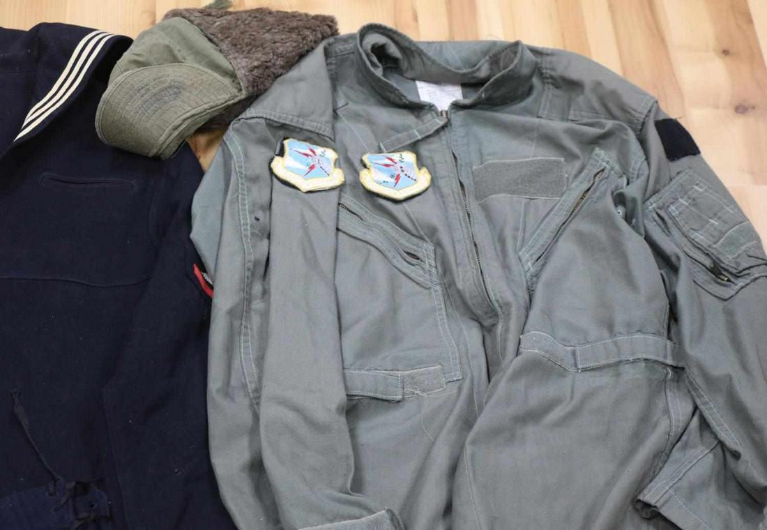 WWII US MILITARY NAVY COVERALL GARRISON CAP LOT: Mixed US military clothing lot: Korean War winter field cap (6 3/4), 5 Garrison side caps, various sizes, 9 finger German helmet liner, size 42R coveralls with Strategic Air Command patch (split in re