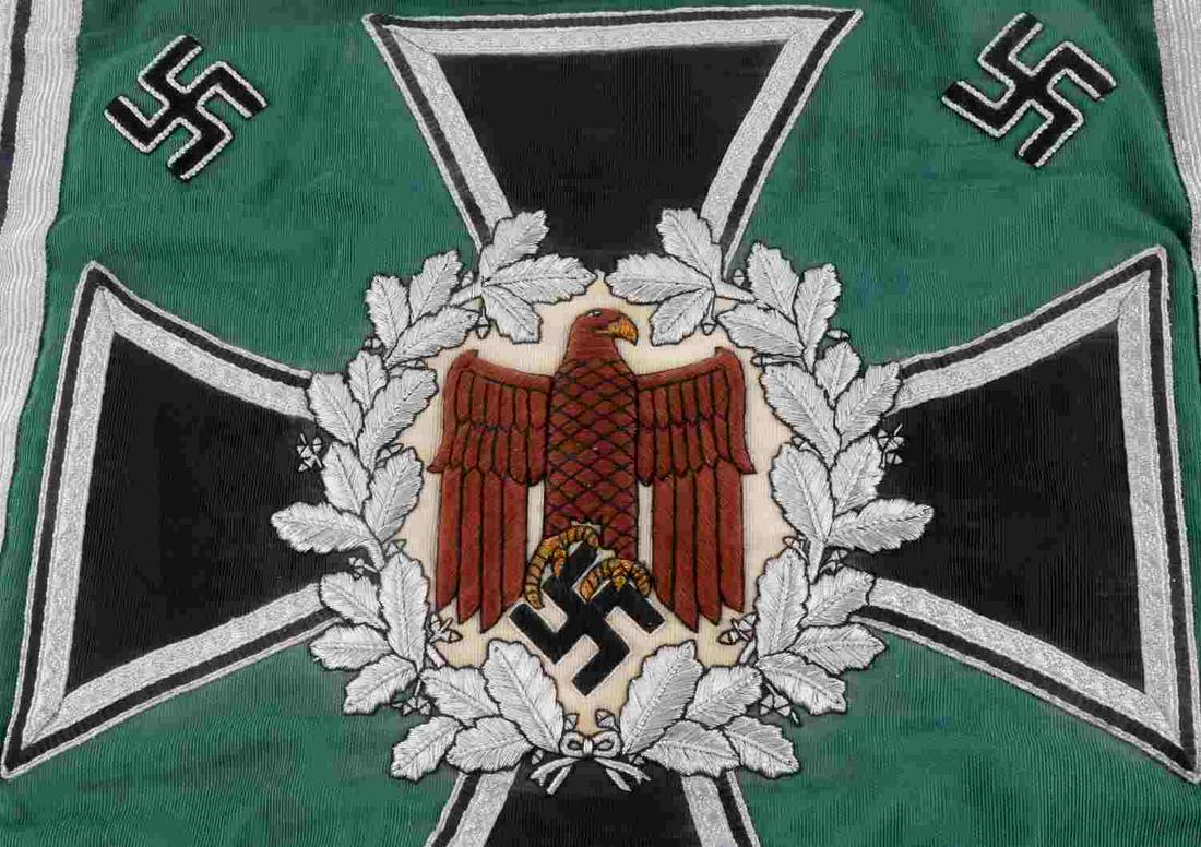 WWII THIRD REICH GERMAN ARMY TRUMPET BANNER: Double-sided green banner with silver bullion and black Iron Cross, eagle at center. Square measures 14 X 13 inches. Some fluorescing to material underneath outermost silver border. Leather straps for
