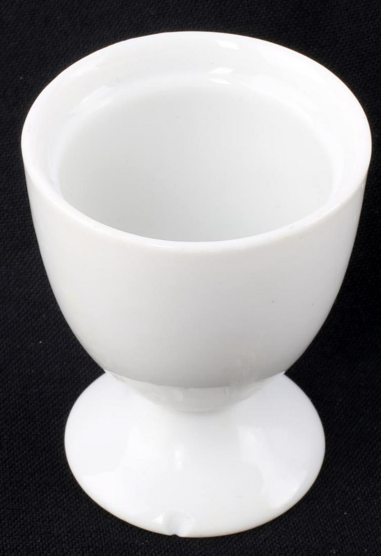 WWII GERMAN LUFTWAFFE PORCELAIN EGG CUP: WWII German Luftwaffe porcelain egg cup. Front features the Luftwaffe eagle in black ink. Bauscher Weiden 1940 maker mark to underside. 2 1/2 inches tall. Loss to the base. Unauthenticated, sold as is