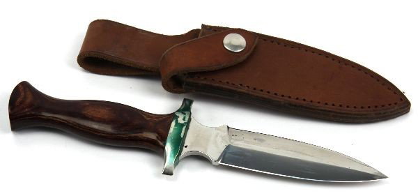 BOOT KNIFE BY TRACK KNIFE OF WHITEFISH MONTANA: One boot knife manufactured by Track Knife, of Whitefish, Montana. 5 inch double edge blade, polished wood handle, and leather scabbard. Some discoloration to cross guard, due to contact with leather,