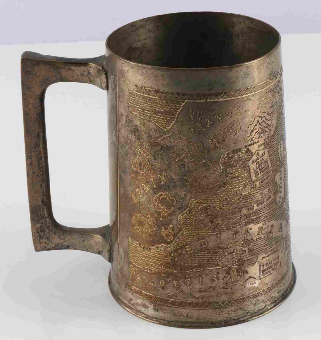 TOOLED BRASS TANKARD MADE FROM WWII BATTLEFIELDS: Tooled design depicting Mediterranean Sea and surrounding countries. German surrender, Italian Navy surrender at Malta, and Bizerte and Tunis Fall dates are also depicted. Stands 5 inches tall. Very g