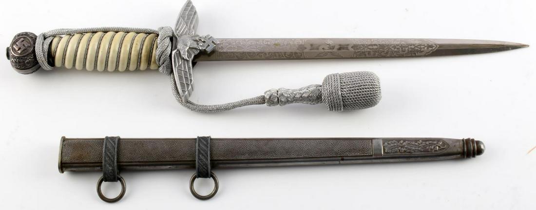 WWII GERMAN THIRD REICH 2ND MODEL LUFTWAFFE DAGGER: Engraved steel blade with most of its original plating remaining. EPS Solingen marked to reverse. Aluminum Reichsadler crossguard. Aluminum oak leaf pommel. Celluloid grip. Housed in pebbled scabbard.