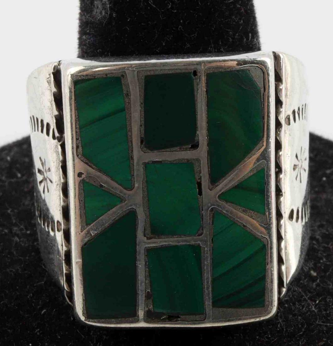 ZUNI MALACHITE INLAY SIGNED STERLING SILVER RING: Zuni malachite inlay silver ring. Signed "C" on reverse. Metal acid tests for sterling. Has detailed work on either side of the ring. Widest point of ring measures approximately 21 millimeters. Ring h