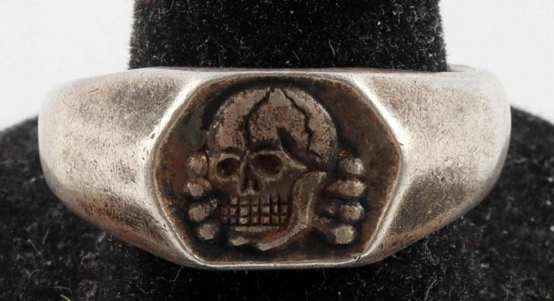 WWII GERMAN THIRD REICH NAMED SILVER SKULL RING: WWII German Third Reich Named Silver Skull Ring; size 9, weighs approx. 10 grams, acid tests as silver. Displays skull and crossbones, with interior shank marked "Narwa 1942" and "800." Very good cond