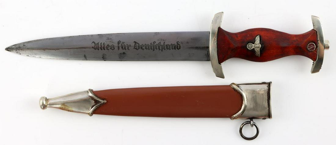 WWII GERMAN THIRD REICH MINIATURE SA HONOR DAGGER: Miniature SA dagger. Nickel crossguards and brown grip with steel blade and inlaid Parteiadler and SA roundel. SA motto acid etched on blade. Measures 7 1/2 inches. Unauthenticated, sold as is. This l