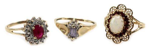 LADIES 10K YELLOW GOLD TANZANITE OPAL RING LOT (3): Size 6.5 ring with an approx. 0.2ct marquis cut tanzanite. Size 7 ring with an approx. 0.48ct oval cut ruby surrounded by (28) approx. 0.01ct round cut diamonds. Size 7 ring with a 8x6mm opal cabochon