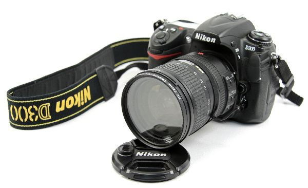 NIKON D300 SLR CAMERA WITH VR 18-200MM LENS: Nikon D300 digital camera with AF-S NIKKOR 18-200 mm F 3.5-5.6 G lens. Includes battery and 8 GB card. Very good condition, missing rubber eye guard. Shutter count: 12,484. Battery charger missing.