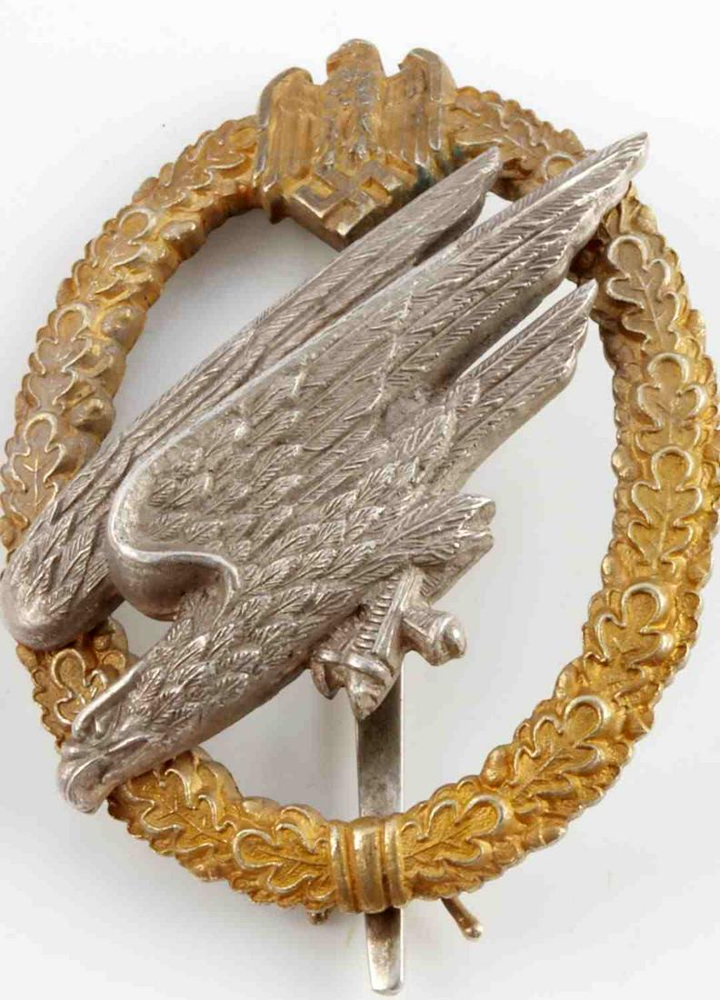WWII GERMAN REICH LUFTWAFFE PARATROOPER BADGE: Diving Reichsadler riveted to oak leaf wreath. Reverse engraved Fallschirm - Inf. Btl. and Kruger Joachim. Eagle marked CE. Junker Berlin and 800. Measures 2 1/8 inches. Very good condition. This lot 