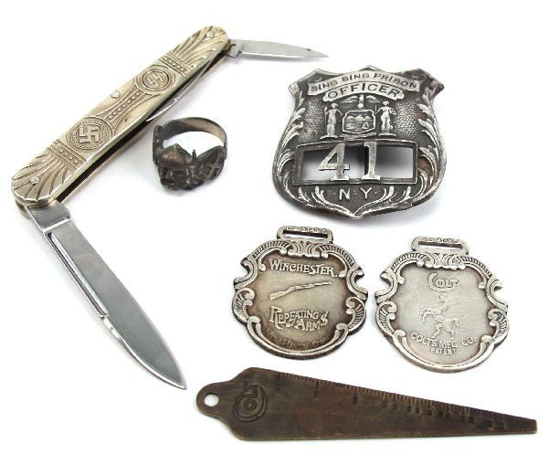 LOT OF SPURIOUS SS KNIFE RING PRISON BADGE & MORE: A grouping of spurious collectibles consisting of a SS Viking ring in silver a SS pocket knife , a Colt and a Winchester silver watch fob, a Colt gauge, Sing Sing prison badge, interesting and collect