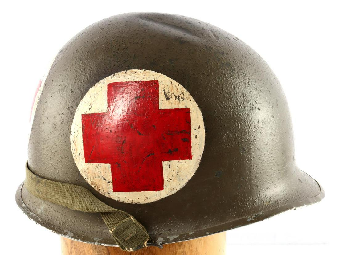 WWII US MILITARY M1 COMBAT MEDIC HELMET WITH LINER: Dark olive green with painted medical crosses on 3 sides. Technician 5th grade insignia on front. B-574 marked to inside. Swivel bale. Illegible painted tag in liner. Very good condition.