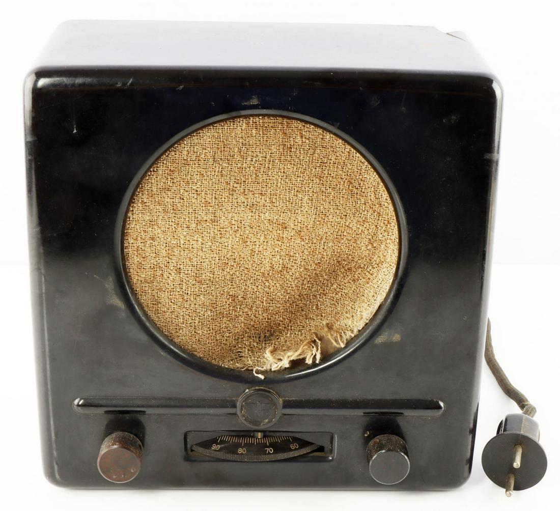 WWII GERMAN THIRD REICH BAKELITE RADIO: Has European plug, appears complete, we have not tested it, Reichsadler above dial front, measures 9 by 9 by 4 inches, area of damage reverse see photo, and torn cloth front.