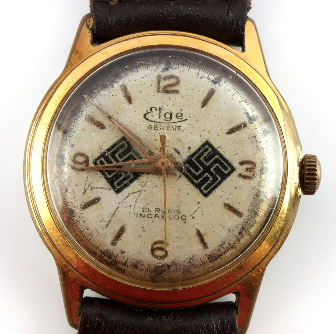 WWII GERMAN THIRD REICH ELGE WRIST WATCH: 9 inches in length watch is 1.5 inches in diameter. Marked on watch face "Elge GENEVE 21 RUBIS INCABLOC" also two swastika decals. Wear consistent with age. Overall in very good condition. Starts and 